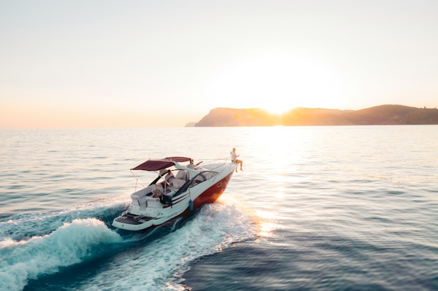 Man riding in a White and Red boat on sea